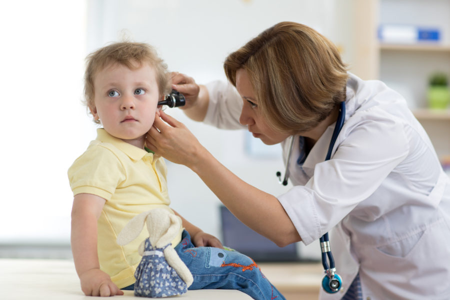 Pediatra mulher examinando o ouvido de uma criança que está com dor de ouvido