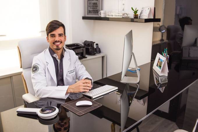 Dr. Fábio Gontijo em sua mesa do consultório