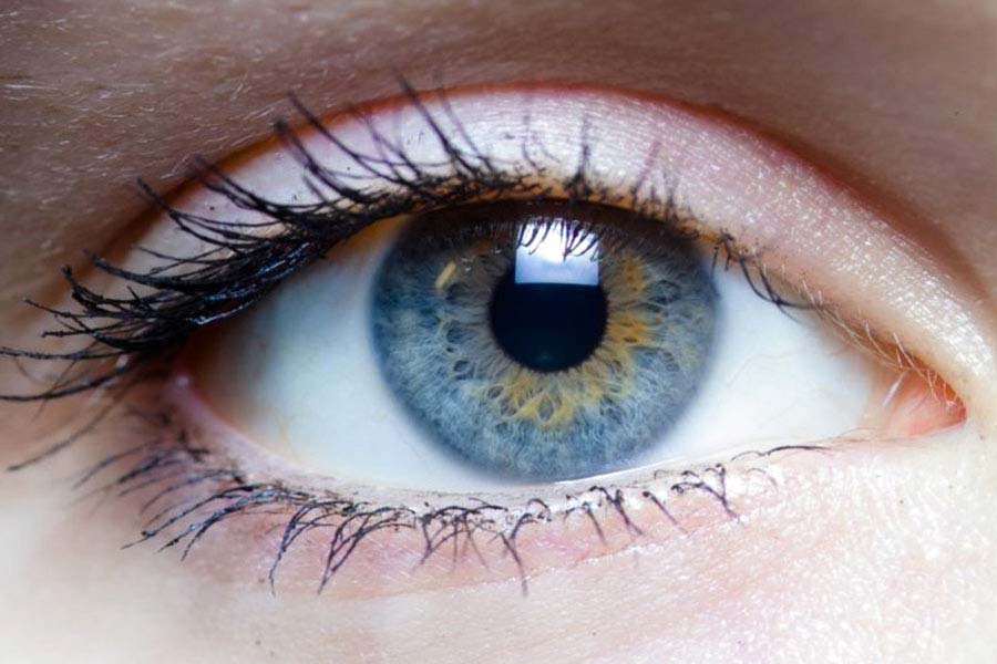Close de um olho azul. Representação da saúde ocular e da relação olho e visão.