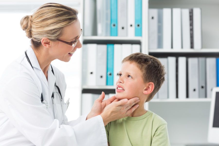 Médica examinando um menino para ver se ele tem caxumba