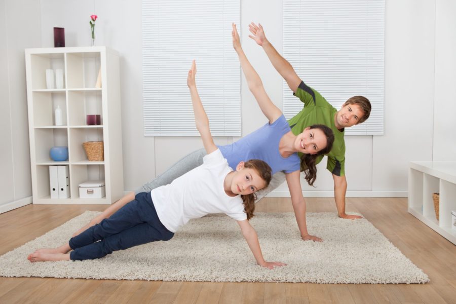 Pais e filha fazendo yoga por conta da medicina do estilo de vida