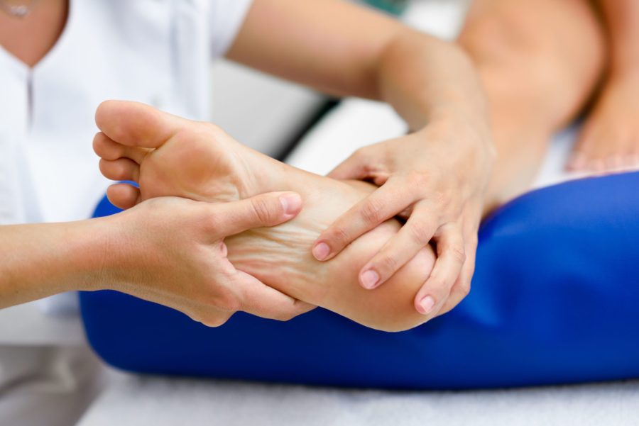 Close de um pé recebendo massagem para tratar dos efeitos do pé diabético