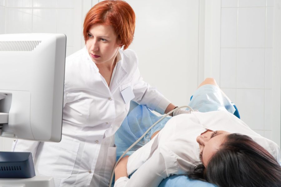 Ginecologista fazendo exame de ultrassom em mulher para descobrir se ela tem câncer de ovário