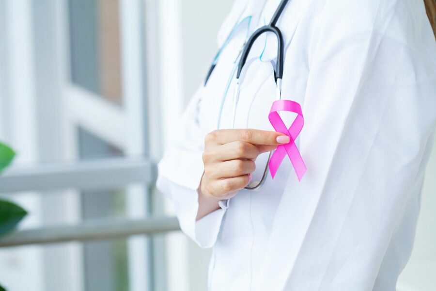 Médico segurando um laço símbolo do do outubro rosa, campanha mundial de conscientização da prevenção de diagnóstico precoce do câncer de mama.