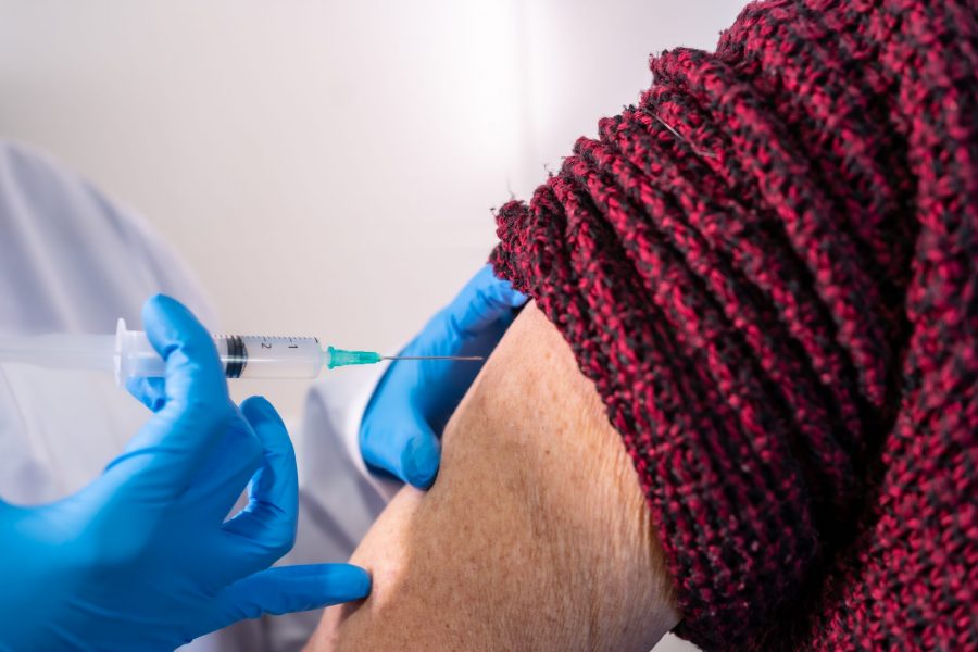 Close de braço de idosa recebendo um dose da vacina contra o covid-19