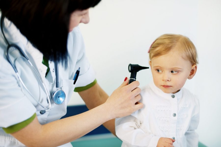 Médica examinando o ouvido de uma criança que está com dor de ouvido
